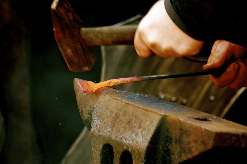 Figure 8: Iron’s strength, malleability, and lower reactivity make it ideal for toolmaking. In this image, a blacksmith heats the metal so that it becomes malleable enough to hammer into shape.